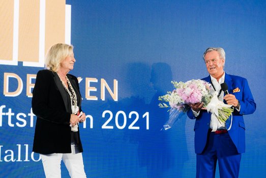 Sabine Christiansen erhält auf der Bühne des Wirtschaftsforums Neu Denken im Juni 2021 einen Blumenstrauß von Willi Plattes.